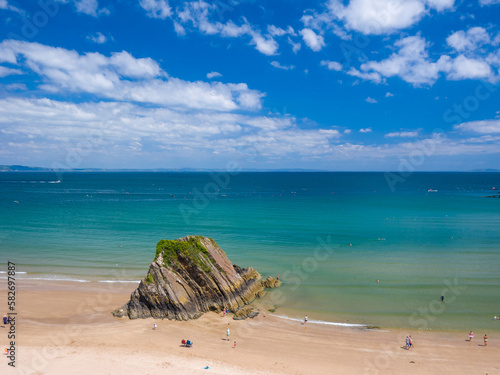 White sandy beach with a big rock on a sunny day (Tenby, Wales, United Kingdom, Fototapet