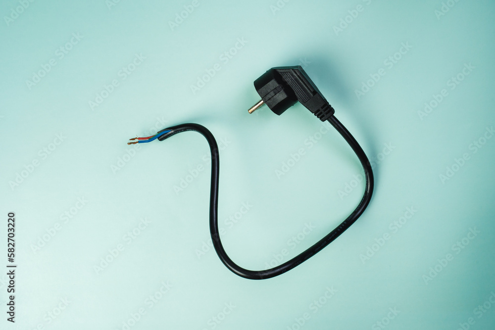 Wire on a light blue background. Copper cable electric stranded wire with black insulation. Curved power cord. Electrical plug Wire on a light blue background. Copper cable electric stranded wire with black insulation. Curved power cord. Electrical plug