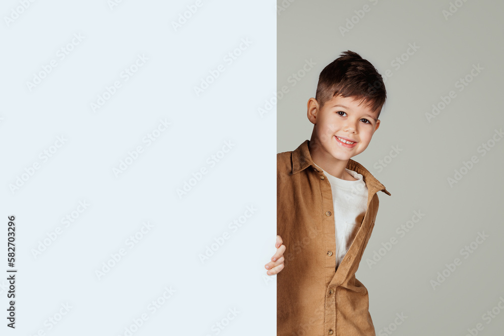 Smiling little european boy with banner with free space for text, ad and offer Smiling little european boy with banner with free space for text, ad and offer