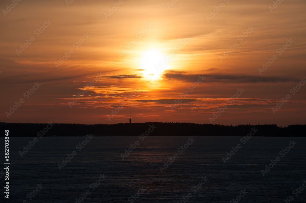 Sunset over a frozen lake and forest in the horizon