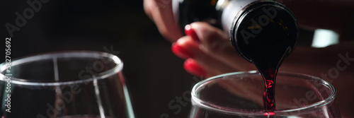 Woman pouring red wine into glass, tasting and degustation photo