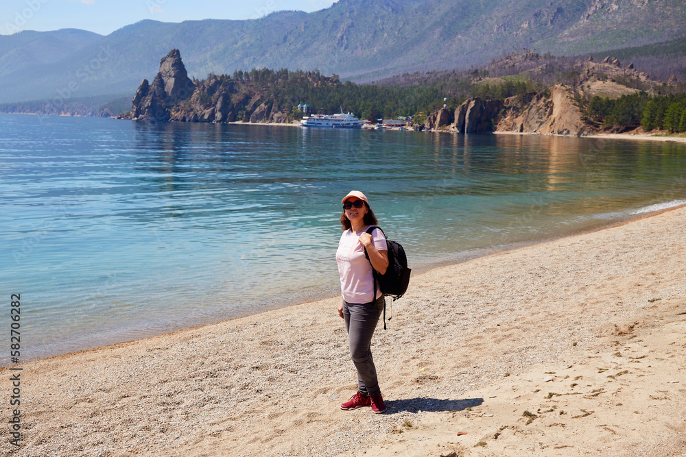 A woman travels on Lake Baikal in the summer. Beautiful view of Cape Kolokolny, Sandy bay. Hiking.