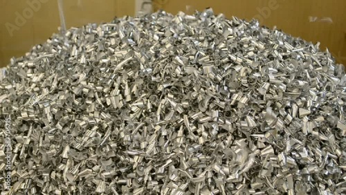 silver metal shaving heap in cardboard container closeup, industrial filing manufacture diversity