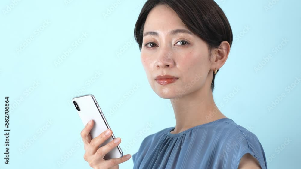 真面目な表情で携帯を持つ日本人女性