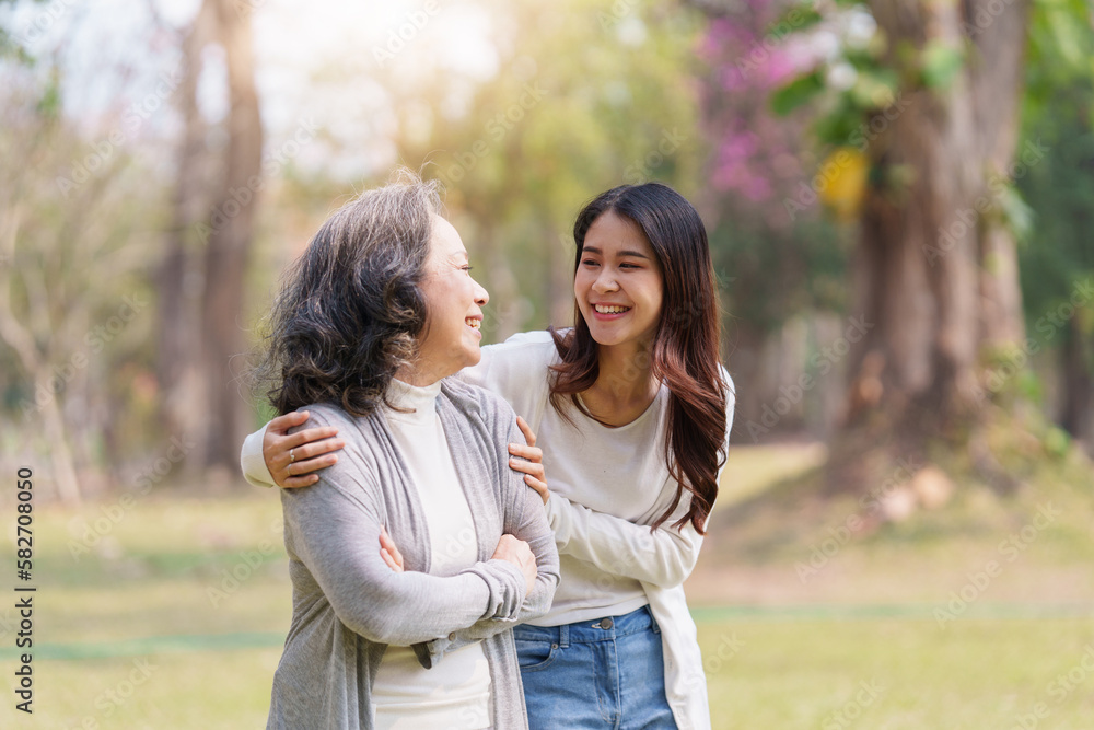 Close up of Adult daughter holding her elderly mother hand with love and walk together Close up of Adult daughter holding her elderly mother hand with love and walk together