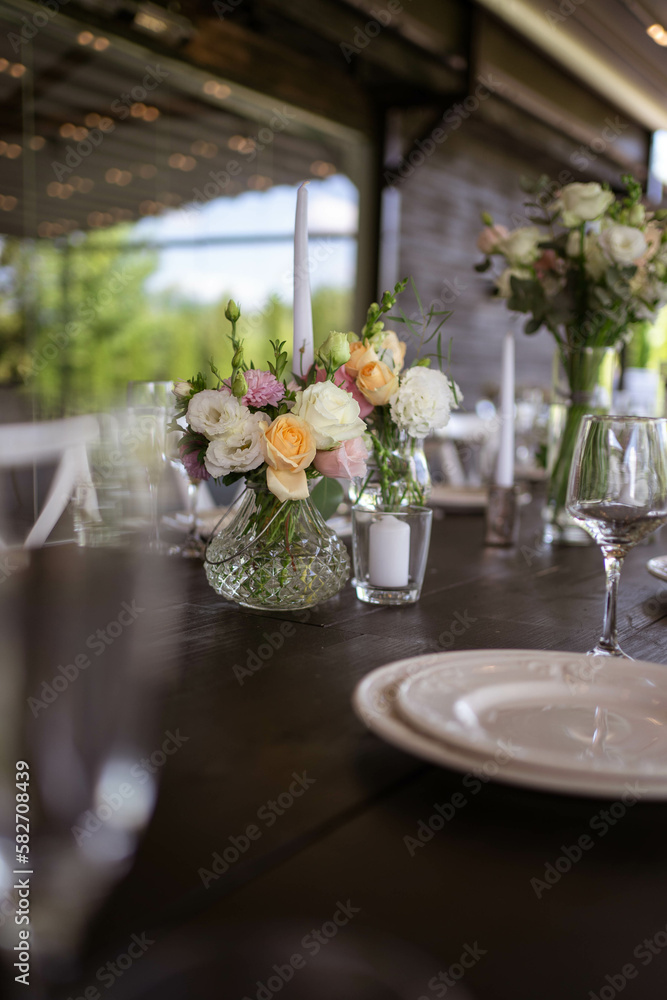 A very nicely decorated wedding table appointments with beautiful decor with plates and serviettes in spring garden. Beautiful flowers on table in wedding day. The elegant dinner table.