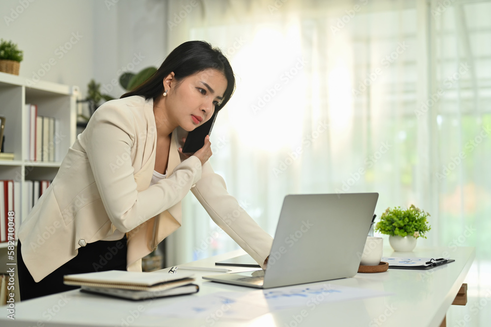 Serious female employee having serious conversation on smartphone, arguing with client or customer