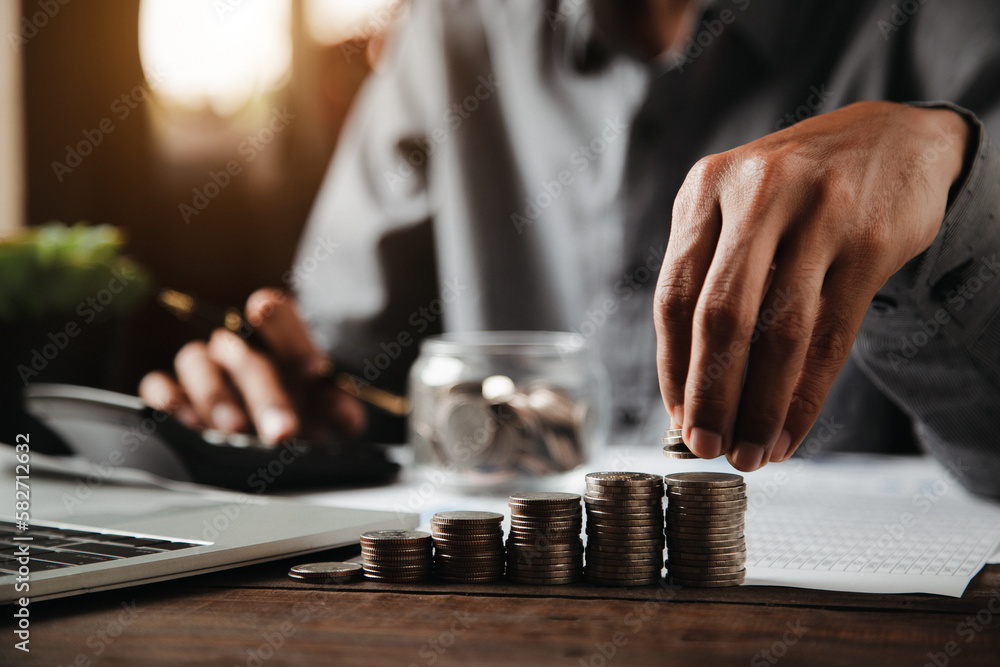 Businessman choose and place pile of coins stack in a graph for money saving planning ideas. Businessman choose and place pile of coins stack in a graph for money saving planning ideas.