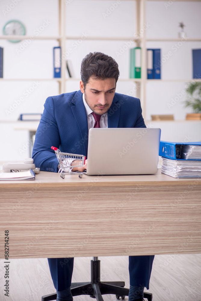 Young male employee in e-commerce concept Young male employee in e-commerce concept