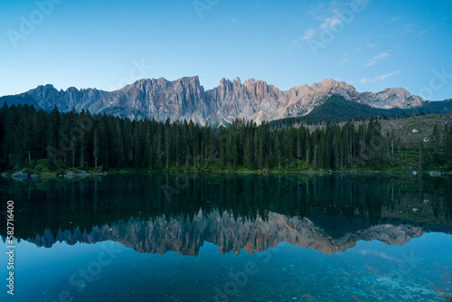 Latemar Gruppe, Felsmassiv, in den Dolomiten in Südtirol im Morgenlicht mit Spiegelung in Bergsee, Karer See.