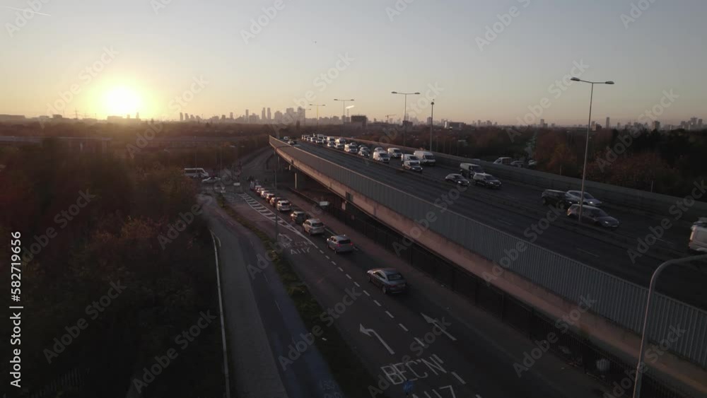 traffic on suburbs with skyline in distance. descending footage against setting sun. London, UK traffic on suburbs with skyline in distance. descending footage against setting sun. London, UK