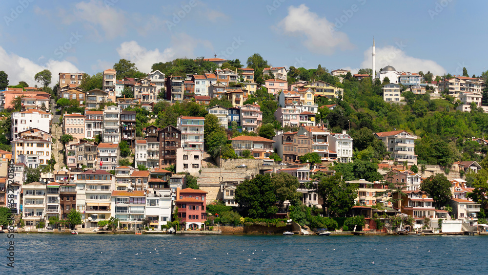 View from the sea of the green mountains of the Europian side of Bosphorus strait, with traditional houses and dense trees in a summer day, Istanbul, Turkey