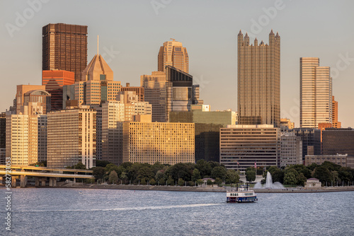 Cityscape of Pittsburgh, Pennsylvania. Allegheny and Monongahela Rivers in Background. Ohio River. Pittsburgh Downtown With Skyscrapers and Beautiful Sunset Sky. Ferry in Roreground