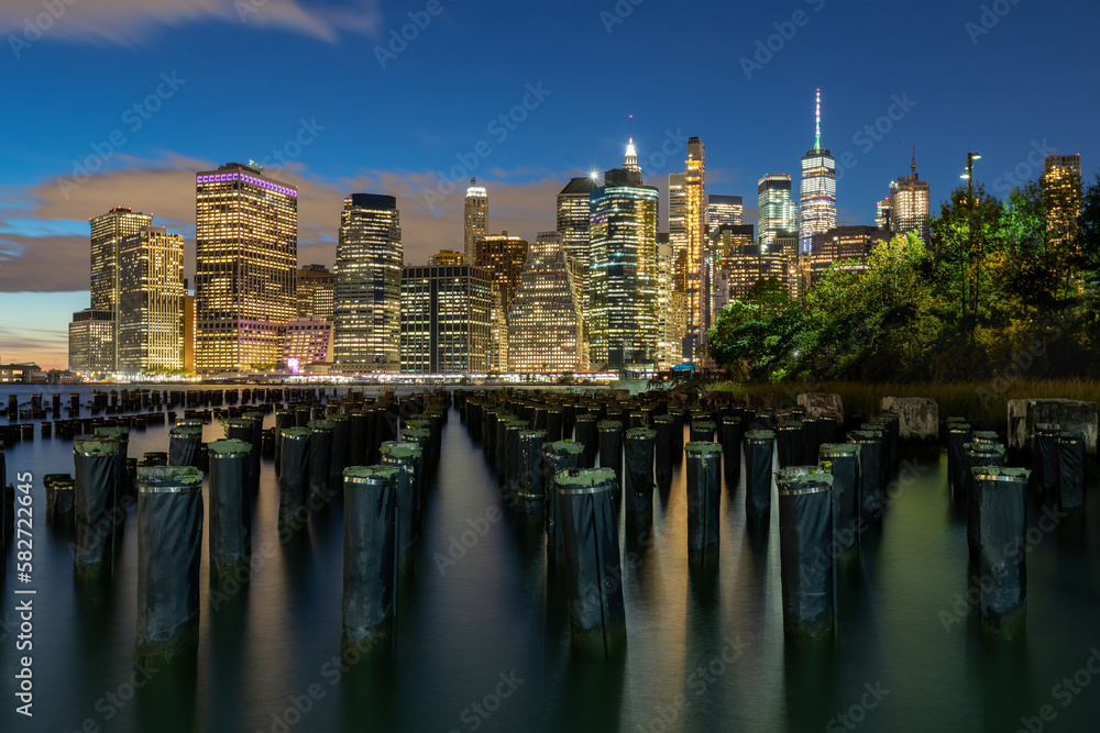 Beautiful Night Light and Lower Manhattan skyline with East River and New York City. Twilight with Reflections and Abandoned Pier