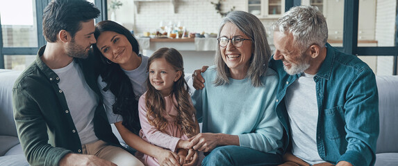 Happy multi-generation family spending time together while sitting on the sofa at home