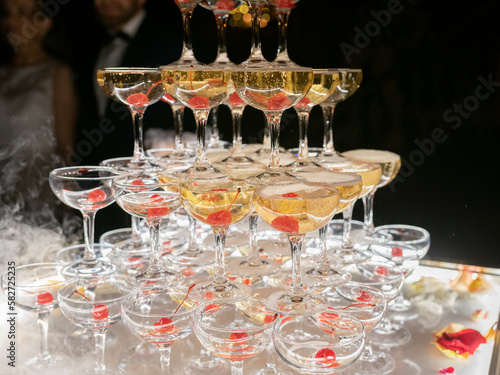 Champagne glasses standing in a tower at the wedding party. Champagne glass pyramid. Pyramid of glasses of wine, champagne, tower of champagne. Wedding party.