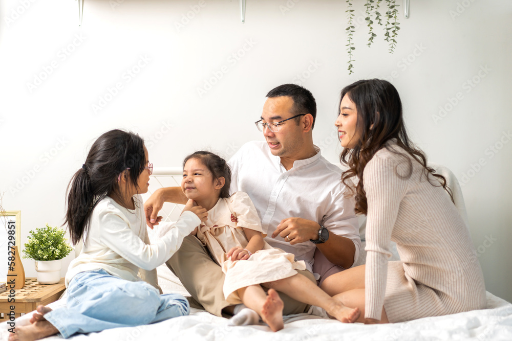 Portrait of enjoy happy love asian family father and mother holding hug cute little asian girl child smiling play and having fun moments good time in at home Portrait of enjoy happy love asian family father and mother holding hug cute little asian girl child smiling play and having fun moments good time in at home