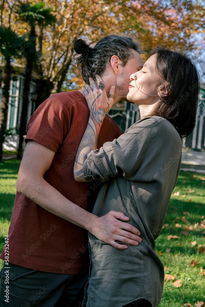 Naklejka premium Candid lifestyle portrait of two happy young people hugging each other in autumn park.