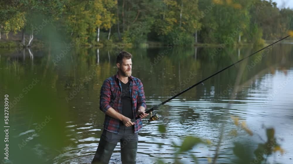 portrait of a stylish man fisherman stands near the shore of a forest lake in autumn portrait of a stylish man fisherman stands near the shore of a forest lake in autumn
