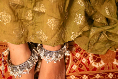 bride wearing silver anklet on wedding function. selective focus.