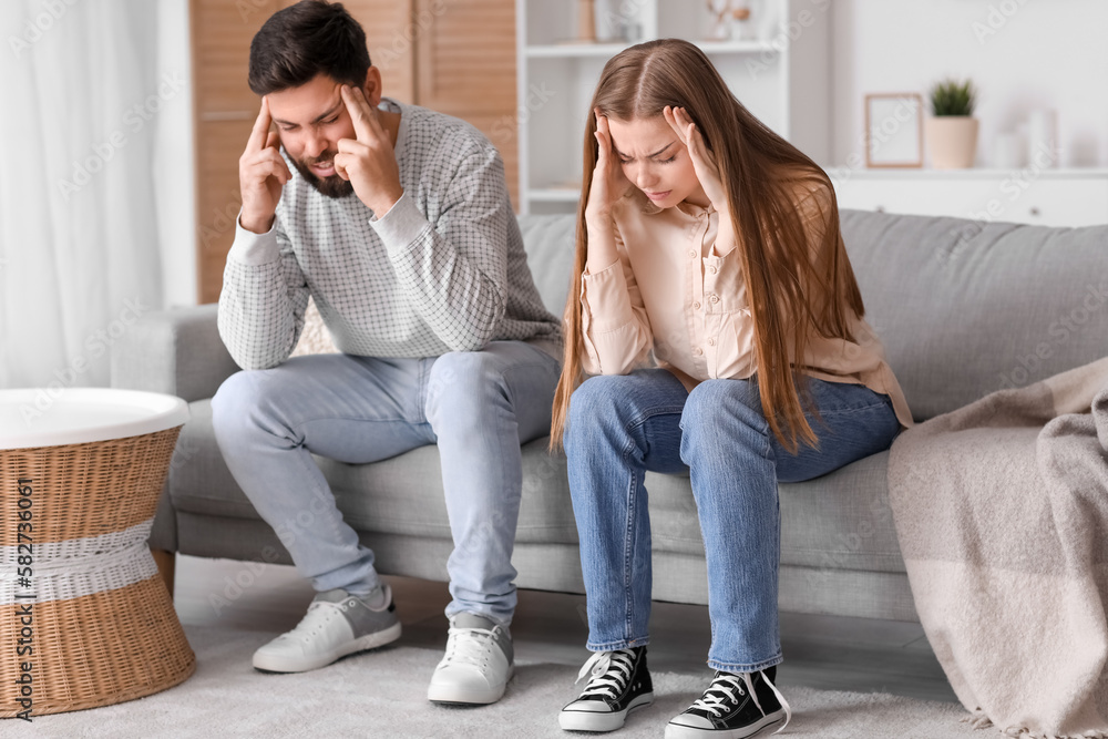 Irritated young couple suffering from loud noise at home Irritated young couple suffering from loud noise at home