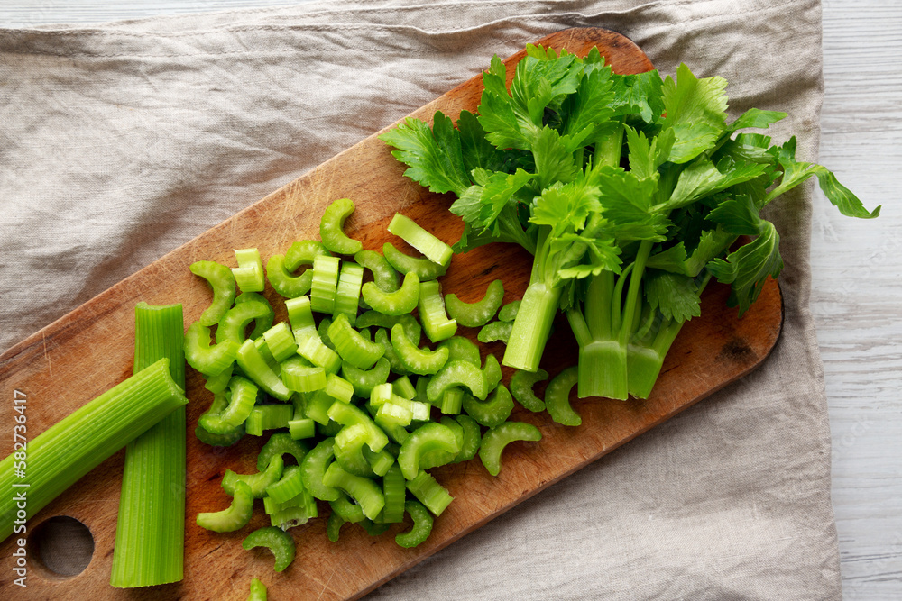 Raw Green Organic Celery on a rustic wooden board, top view. Flat lay, overhead, from above. Raw Green Organic Celery on a rustic wooden board, top view. Flat lay, overhead, from above.