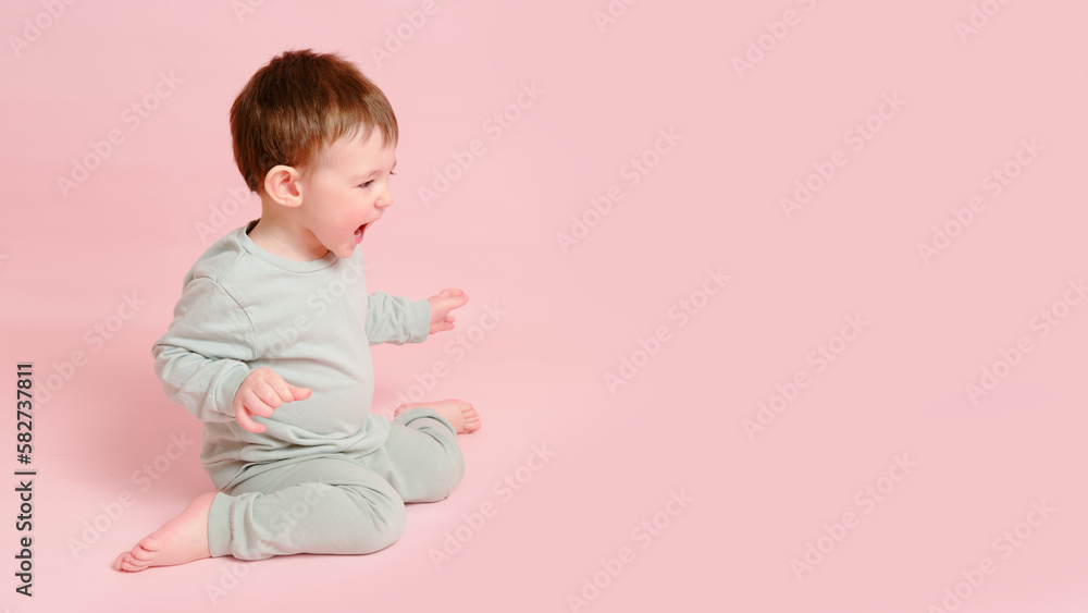 Happy toddler baby on studio pink background, copy space. Emotional child boy with a smile on his face, full height. Kid age one year eight months Happy toddler baby on studio pink background, copy space. Emotional child boy with a smile on his face, full height. Kid age one year eight months