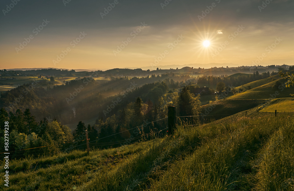 Sonnenaufgang über der Hügellandschaft bei Menzingen. 