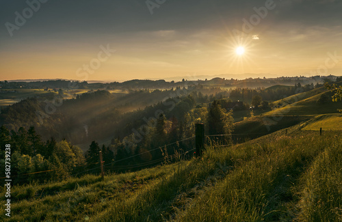 Sonnenaufgang über der Hügellandschaft bei Menzingen. 