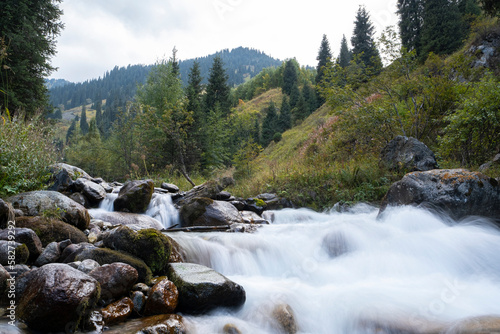 Landscape of a mountain river on a long exposure. The river in the passage gorge is not far from the city of Almaty. A beautiful stormy river with clear water.