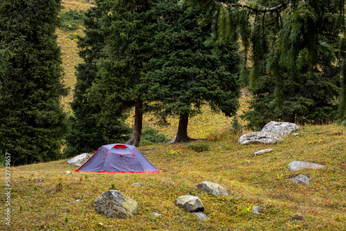 Several tents on the site in the mountains. A family camping place in the mountains.