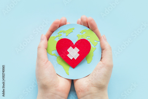 Wallpaper Mural world cardiologist day. health day concept. Female hands hold a paper model of the globe with a heart Torontodigital.ca