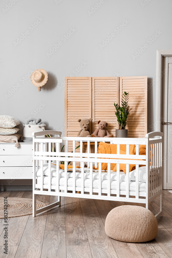 Interior of children's bedroom with baby crib and commode Interior of children's bedroom with baby crib and commode