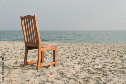 A chair with no people on the sea beach in front of a minimalist background. relax on lonely beach. sea sand sky concept. summer vacation. copy space.