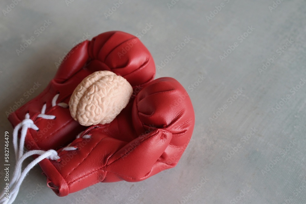 Human brain model on top of boxing gloves with copy space. Fight brain