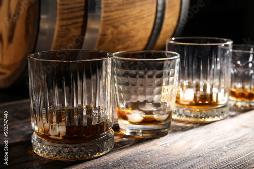 Glasses of cold whiskey on dark wooden background