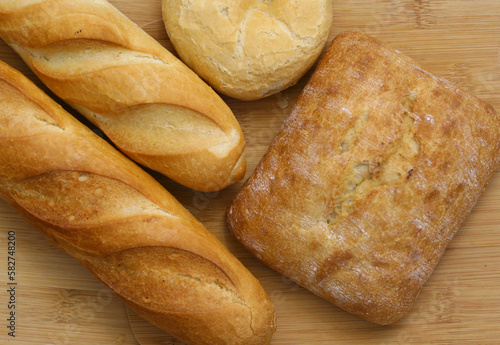 Several types of bread. Bun, baguettes, ciabatta shot from above (top view, flat lay)