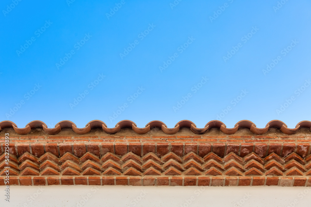 Beautiful Spanish-style Brickwork on Overhanging Roof against Blue Sky for backgrounds, textures, and presentations