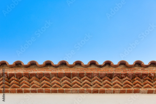 Beautiful Spanish-style Brickwork on Overhanging Roof against Blue Sky for backgrounds  textures  and presentations