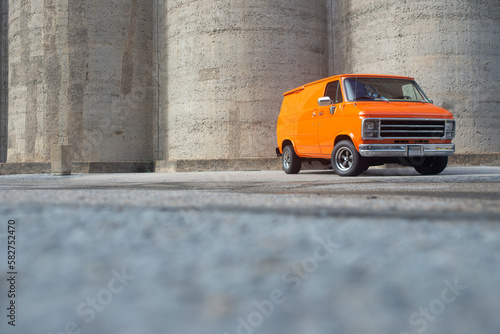 Konstfotografi Orange 70’s boogie van front 3/4 view landscape, with concrete background