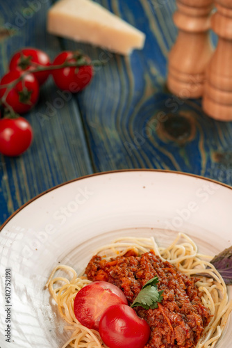 italian Pasta bolognese with meat, tomato sauce and vegetables in blue wooden desk .