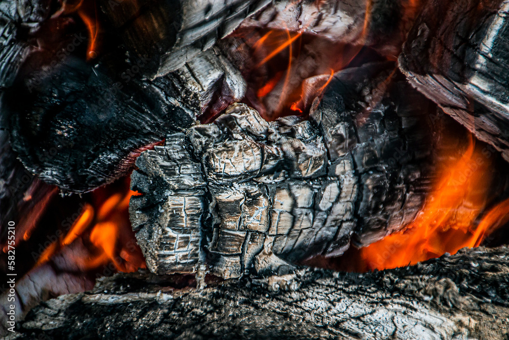 Large burning firewood with ashes in a bonfire closeup Large burning firewood with ashes in a bonfire closeup