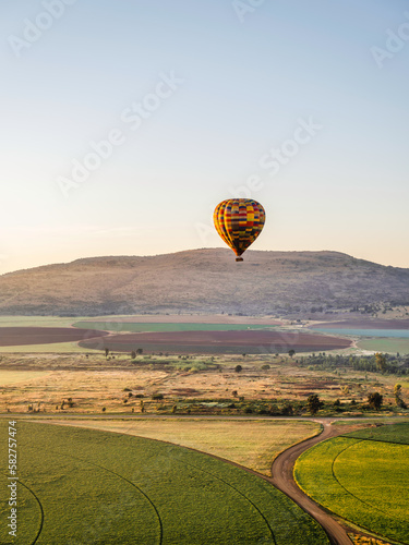 Colourful hot air balloons flying over circular crop fields in Magaliesburg, Gauteng, South Africa