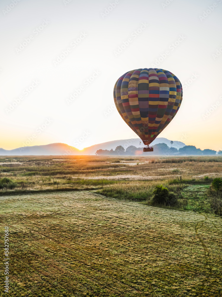 Obraz premium Hot air balloon flying over the field in Magaliesburg during sunrise, Gauteng, South Africa