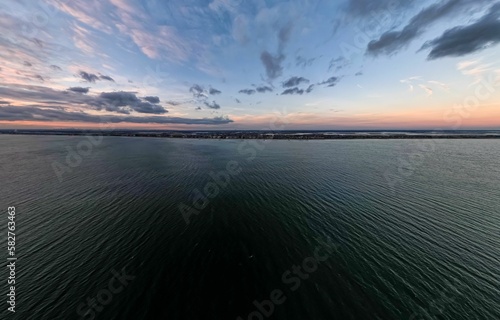 Drone shot of the seascape and the Long Beach on the horizon at sunset in New York, United States photo