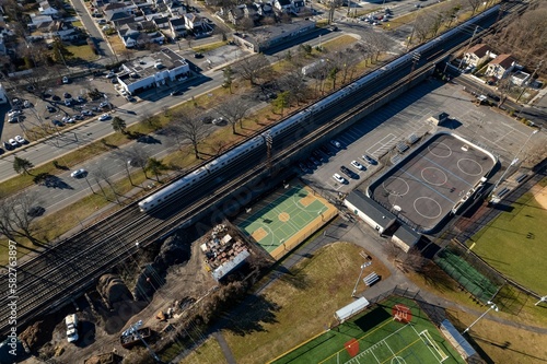 Aerial view over a commercial neighborhood on Long Island, NY on a sunny day with a train line