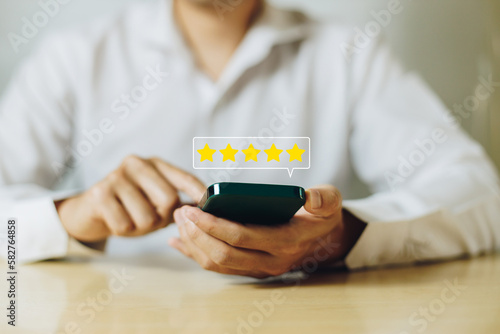 Customer holding smartphone giving a five star rating. Concept of service rating, satisfaction and feedback