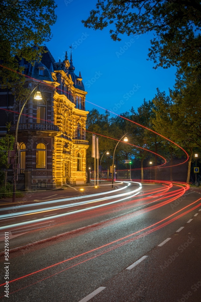 Vertical motion blur of a highway road with an ancient building on the side at nighttime