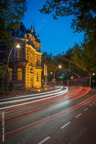 Vertical motion blur of a highway road with an ancient building on the side at nighttime