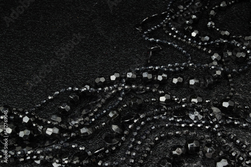 Beautiful black bead necklaces on a black background photo